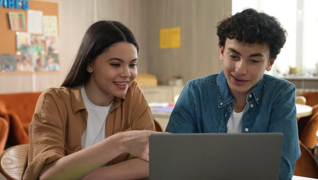 Idea de proyecto Building Safe Digital Futures: dos estudiantes miran juntos un portátil.