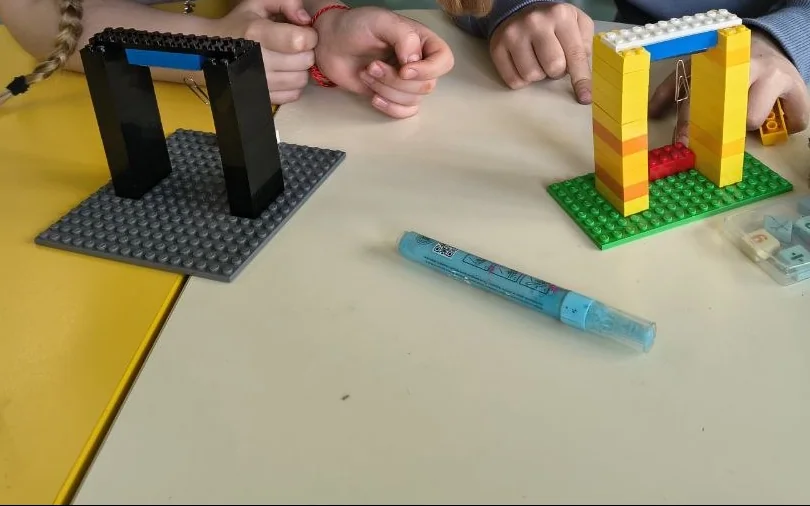 Dos arcos que el alumnado construyó con bloques sobre una mesa del aula.