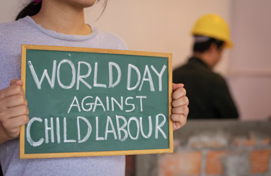 Crafting Compassion: Weaving Hope for Children's Rights — a young student holding a chalkboard sign reading 'World Day Against Child Labour' to mark World Day Against Child Labor on June 12