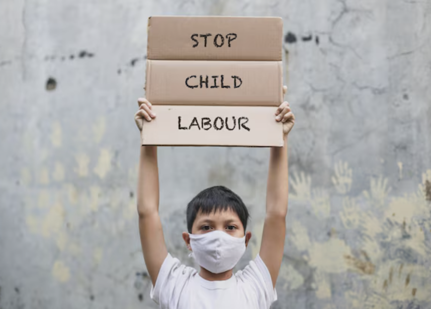 Advocates in Action: Uniting Youth to Combat Child Labor — a young teen holding cardboard signs reading 'STOP CHILD LABOUR' for World Day Against Child Labor on June 12