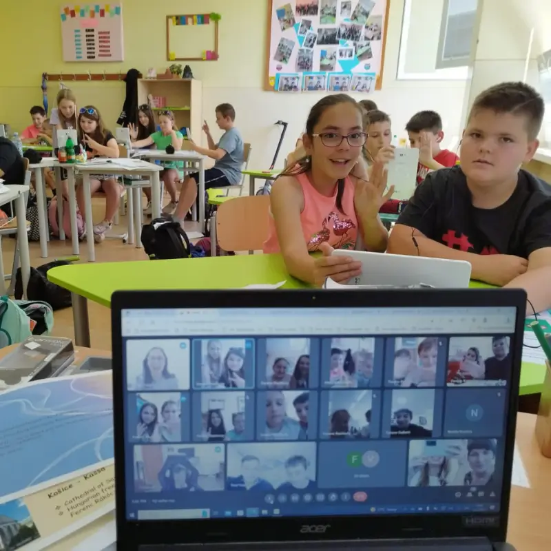 Students collaborating in classroom using digital devices