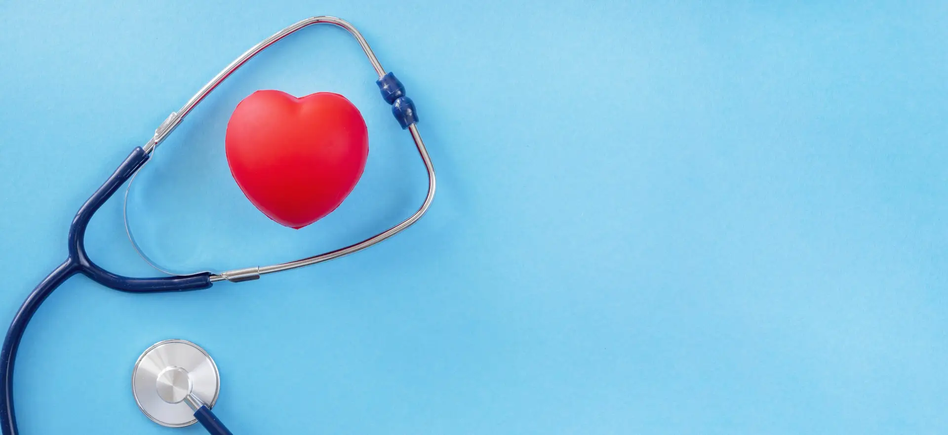 Top view heart shape with stethoscope on blue background for World Health Day