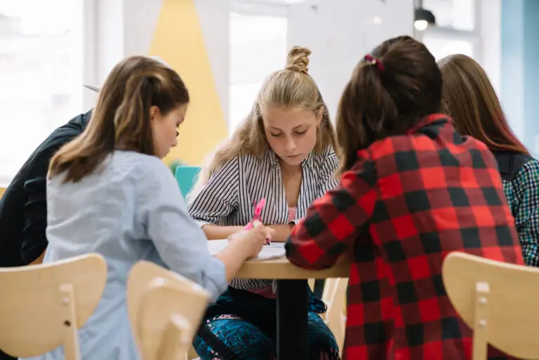 Un grupo de estudiantes posando juntos alrededor de una mesa