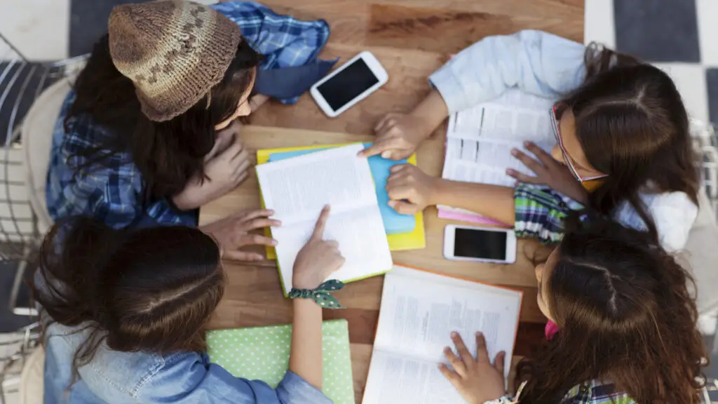 Students collaborating on a group project in a classroom, an active learning approach that shows why students forget what they learn through passive instruction